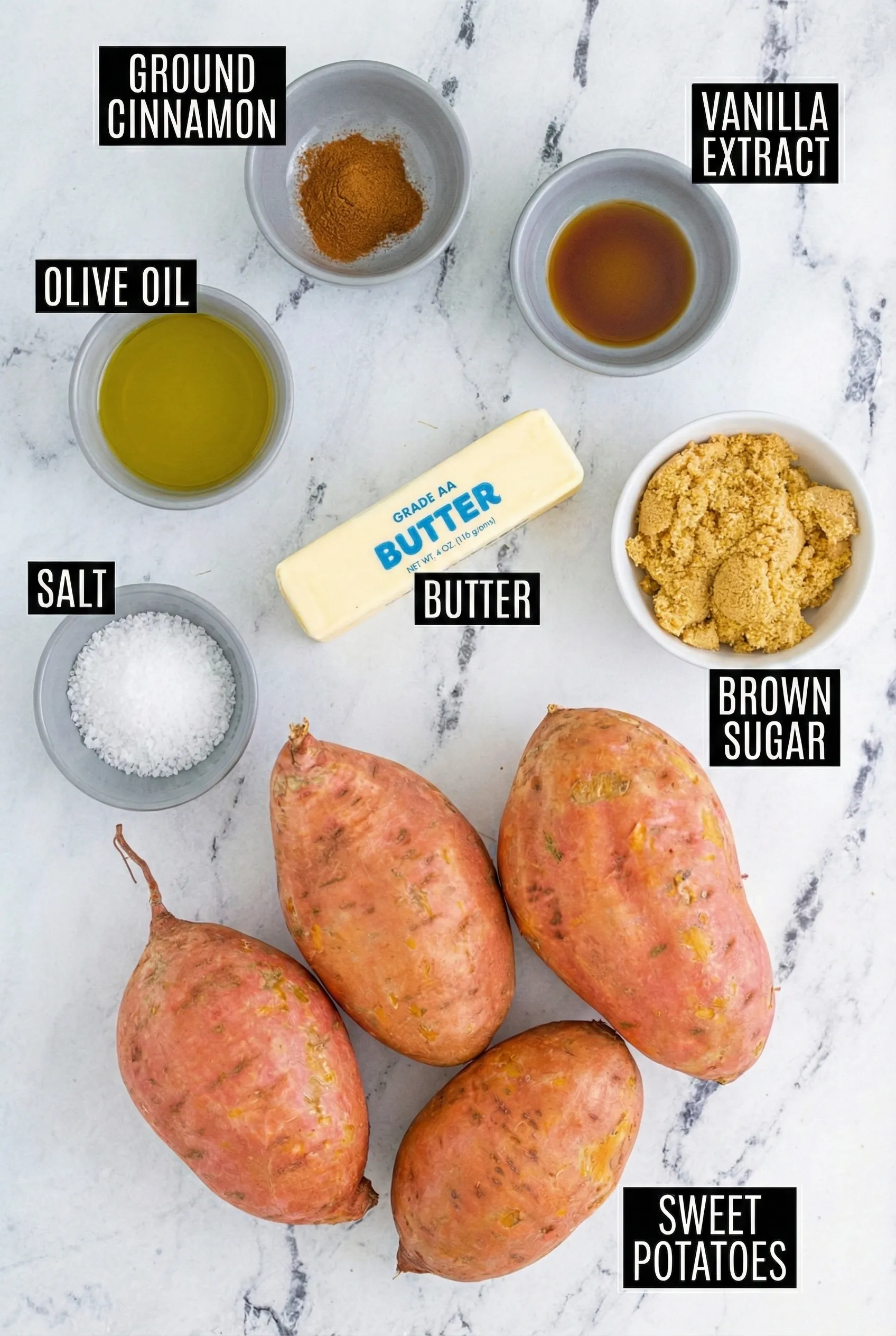 cinnamon butter baked sweet patato ingredients An overhead shot of the ingredients needed for cinnamon butter baked sweet potatoes arranged on a white marble surface. The image includes four raw sweet potatoes, a stick of butter, bowls of brown sugar, ground cinnamon, vanilla extract, olive oil, and salt, all with clear text labels.