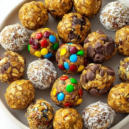 Top-down view of a plate filled with assorted no-bake energy bites, including variations with colorful candies, shredded coconut, and chocolate chips.