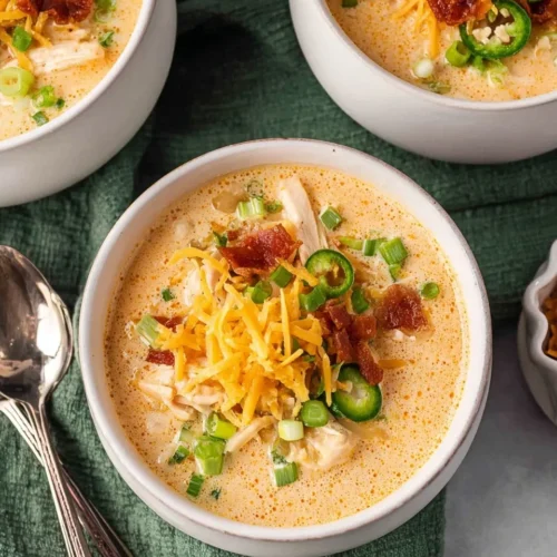 Pinterest graphic featuring two photos of creamy Crockpot Jalapeño Popper Chicken Soup garnished with fresh peppers and paprika, with a text overlay reading "Crockpot Jalapeño Popper Chicken Soup: Just 10 Minutes Prep - Creamy & Spicy Perfection."
