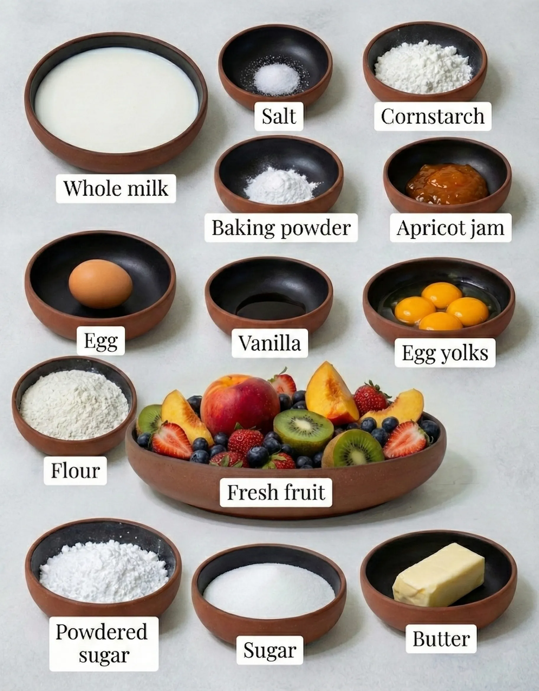ingredients for a fresh fruit tart recipe Overhead view of pre-measured ingredients for a fresh fruit tart recipe arranged in small bowls, including whole milk, butter, sugar, flour, egg yolks, apricot jam, and a vibrant bowl of fresh fruit.