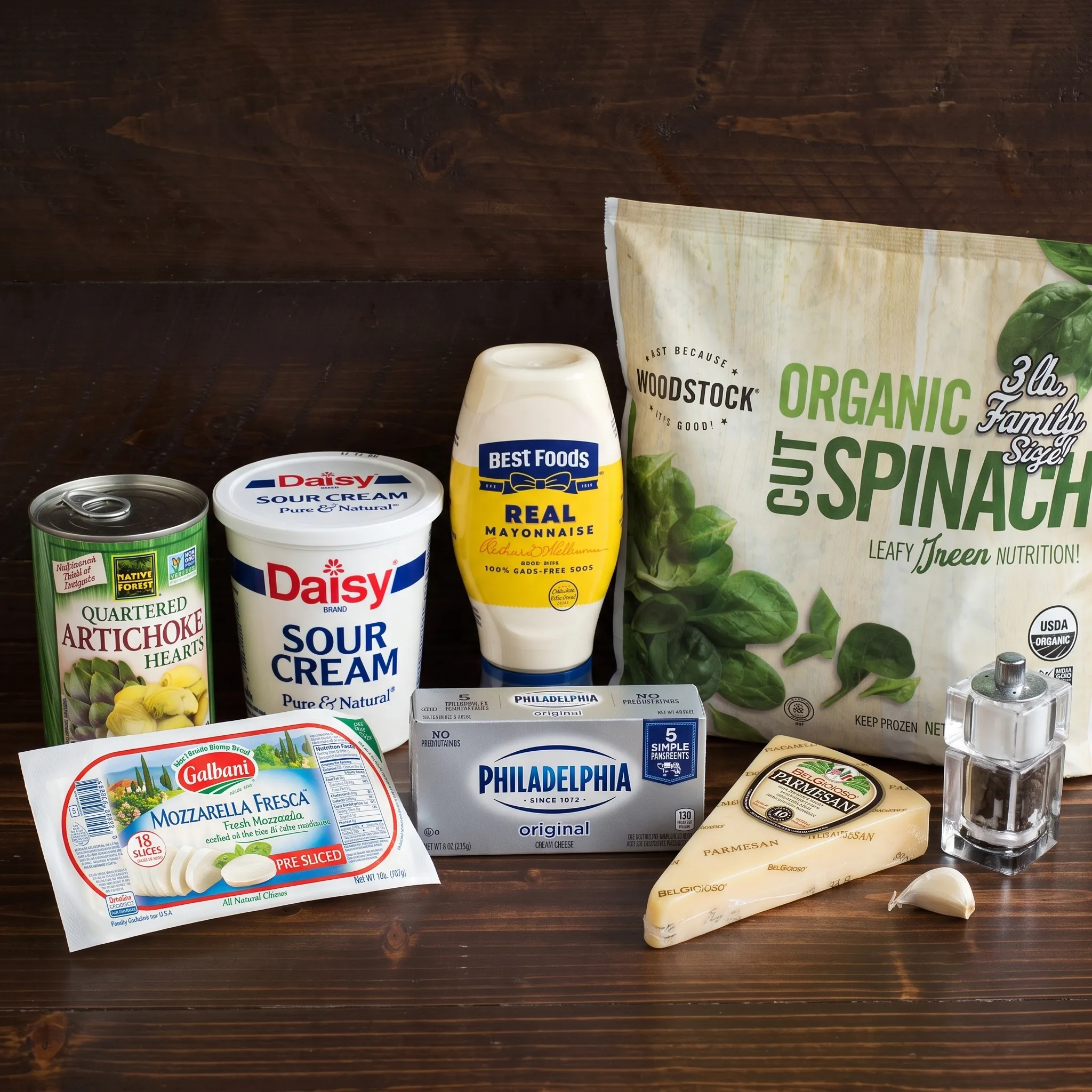 Ingredients for spinach artichoke dip: spinach, artichoke hearts, cream cheese, sour cream, mayonnaise, cheeses.